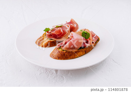 Elegant prosciutto bruschetta on white plate 114801878