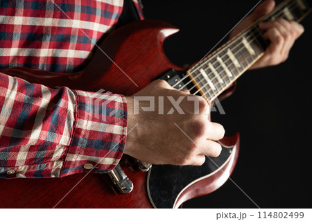 A man plays a beautiful guitar close-up 114802499