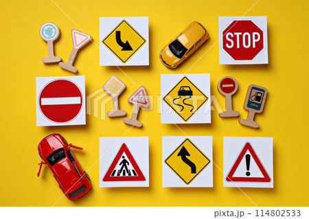 Road signs and vehicles on a yellow background. 114802533