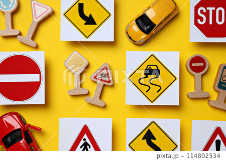 Road signs and vehicles on a yellow background. 114802534