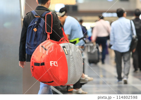 大きな荷物を肩にかけた空港の利用客 出発ロビーの利用客 大きな荷物を肩にかけた空港の利用客 出発ロビーの利用客 114802598