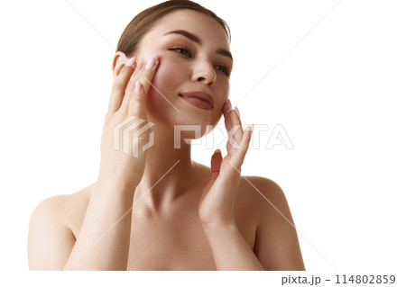 Young beautiful brunette girl touching and enjoy her moisturized facial skin after treatments against white studio background. Young beautiful brunette girl touching and enjoy her moisturized facial skin after treatments against white studio background. 114802859
