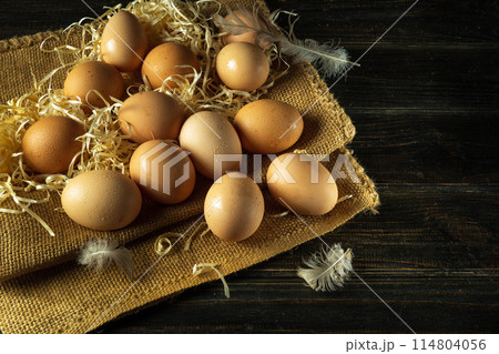 A pile of chicken eggs with straw and feathers. Eggs are collected to make a healthy breakfast or dinner. Advertising space A pile of chicken eggs with straw and feathers. Eggs are collected to make a healthy breakfast or dinner. Advertising space 114804056
