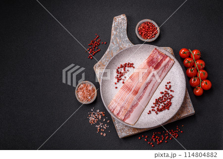 Delicious bacon in the form of slices with salt, spices and herbs Delicious bacon in the form of slices with salt, spices and herbs 114804882