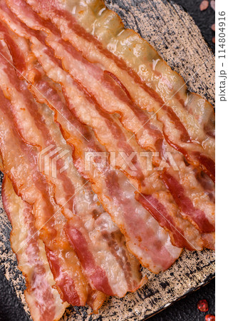 Delicious bacon in the form of slices with salt, spices and herbs Delicious bacon in the form of slices with salt, spices and herbs 114804916