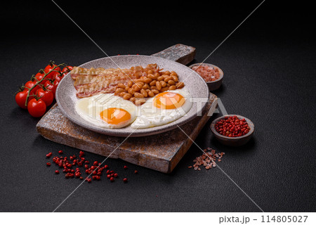 English breakfast with fried eggs, bacon, beans, tomatoes, spices and herbs English breakfast with fried eggs, bacon, beans, tomatoes, spices and herbs 114805027