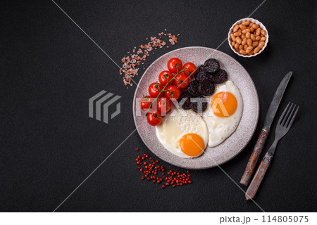 English breakfast with fried eggs, bacon, beans, tomatoes, spices and herbs 114805075