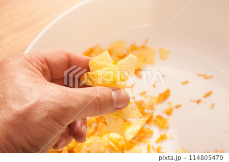 There are potato chips in a white plate, a caucasian person is holding potato chips in his hand There are potato chips in a white plate, a caucasian person is holding potato chips in his hand 114805470