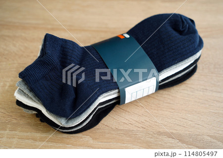 Package of multi-colored men's socks short, woven socks packaged, on a wooden floor Package of multi-colored men's socks short, woven socks packaged, on a wooden floor 114805497