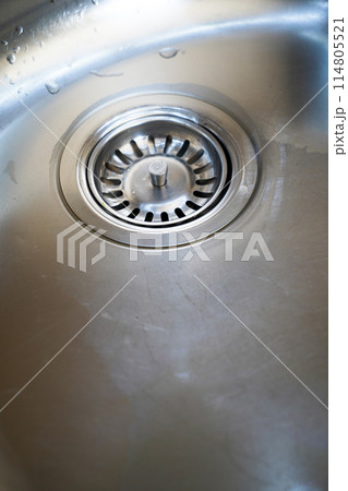 Stainless steel sink and water drain in a modern kitchen, water flow in the kitchen sink Stainless steel sink and water drain in a modern kitchen, water flow in the kitchen sink 114805521