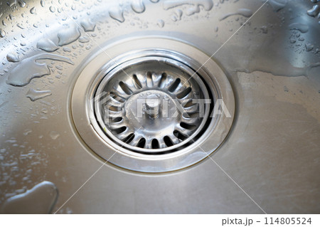 Stainless steel sink and water drain in a modern kitchen, water flow in the kitchen sink 114805524