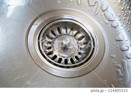 Stainless steel sink and water drain in a modern kitchen, water flow in the kitchen sink 114805525