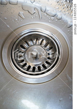 Stainless steel sink and water drain in a modern kitchen, water flow in the kitchen sink Stainless steel sink and water drain in a modern kitchen, water flow in the kitchen sink 114805526