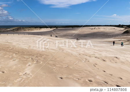 Beachgoers on the white sand dunes of Leba in the Slovincian National Park 114807808
