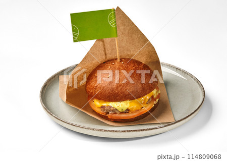Hamburger with beef patty in paper wrap on plate Hamburger with beef patty in paper wrap on plate 114809068