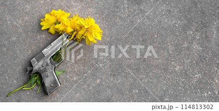 Gun and yellow flowers on asphalt. concept of memory, fragility of peace, no war, stop war, world peace, pacifism. Banner, copy space, text space, template, layout, mockup Gun and yellow flowers on asphalt. concept of memory, fragility of peace, no war, stop war, world peace, pacifism. Banner, copy space, text space, template, layout, mockup 114813302