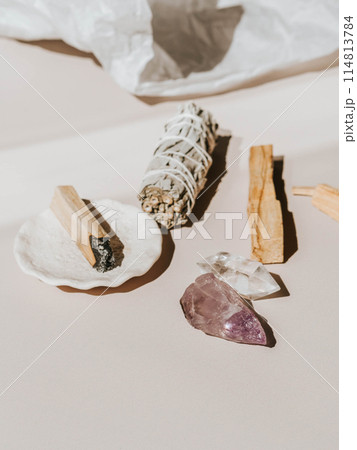 White sage and Palo Santo and amethyst and quartz crystals on a light beige background 114813784