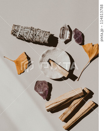 White sage and Palo Santo and amethyst and quartz crystals on a light beige background. 114813788