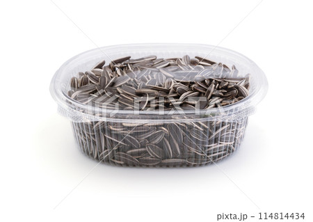 Sunflower seeds in a plastic container isolated. Sunflower seeds in a plastic container isolated. 114814434