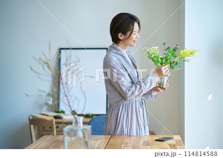 花を飾った花瓶を持つ女性 114814588