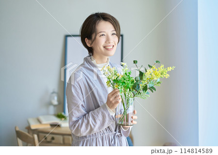 花を飾った花瓶を持つ女性 114814589