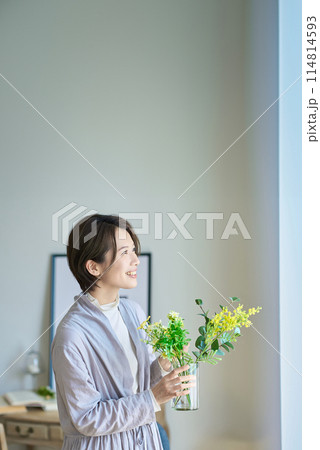 花を飾った花瓶を持つ女性 114814593