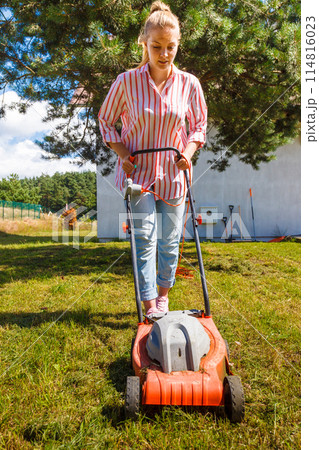 Woman mowing green grass 114816023