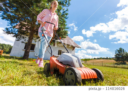 Woman mowing green grass 114816026