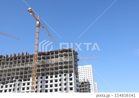 Construction of new residential high-rise buildings. Against the background of a yellow sunset sky. 114816141