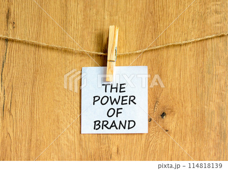 The power of brand symbol. Concept words The power of brand on beautiful white paper on clothespin. Beautiful wooden background. Business the power of brand concept. Copy space. The power of brand symbol. Concept words The power of brand on beautiful white paper on clothespin. Beautiful wooden background. Business the power of brand concept. Copy space. 114818139