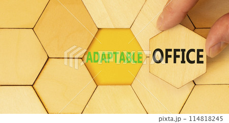 Adaptable office symbol. Concept words Adaptable office on beautiful wooden puzzles. Beautiful yellow background. Businessman hand. Business Adaptable office concept. Copy space. Adaptable office symbol. Concept words Adaptable office on beautiful wooden puzzles. Beautiful yellow background. Businessman hand. Business Adaptable office concept. Copy space. 114818245