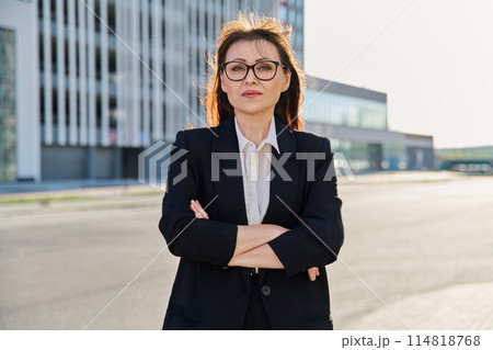 Portrait of middle-aged business confident woman in suit, posing outdoors 114818768