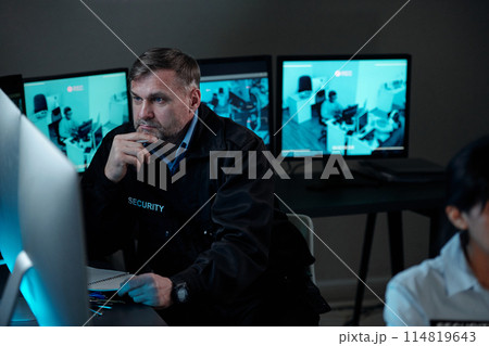 Concentrating on watching cctv video 114819643