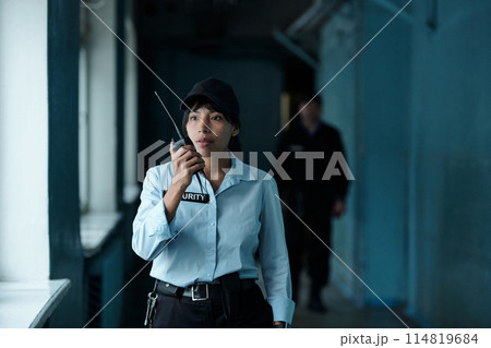 Female guard speaking on walkie-talkie Female guard speaking on walkie-talkie 114819684
