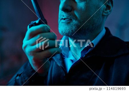 Mature guard speaking in walkie-talkie 114819693