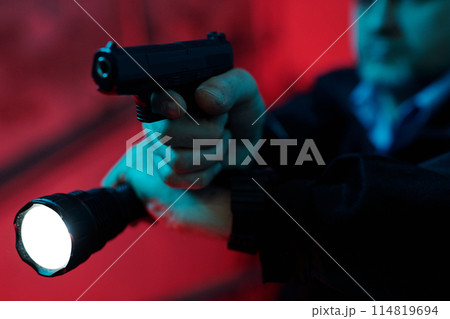 Guard with flashlight ready to shoot 114819694