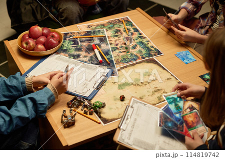 Kids looking through board game cards Kids looking through board game cards 114819742