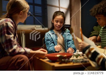 Smiling youthful girl with dice in hand 114819779
