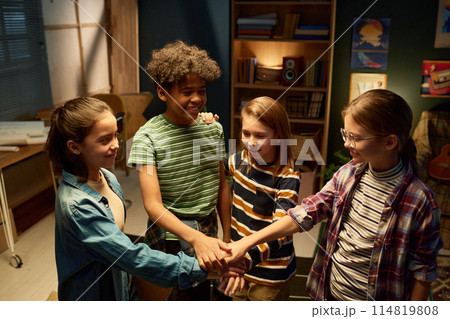 Happy kids making pile of hands 114819808