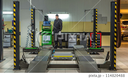 Car on stand with sensors on wheels for wheels alignment camber check in workshop of Service station timelapse. Car on stand with sensors on wheels for wheels alignment camber check in workshop of Service station timelapse. 114820488