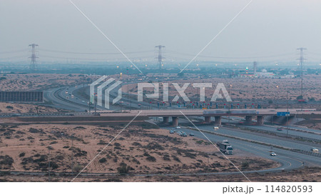 Highway roads with traffic day to night timelapse in a big city from Ajman to Dubai before sunset. Transportation concept. 114820593