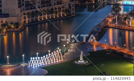 Top close up view of the bridge over man-made lake and some people walking in park 114820945
