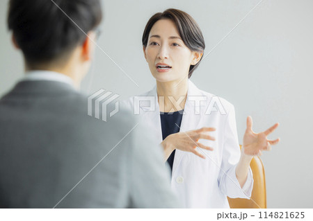 説明する女性医師 114821625