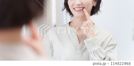 鏡を見て歯のチェックをするミドル女性（美容・歯列矯正・ホワイトニング） 114822968