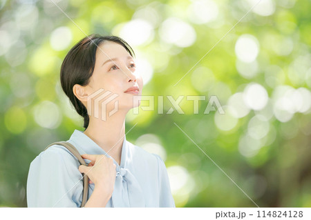 新緑の中で微笑む女性 114824128