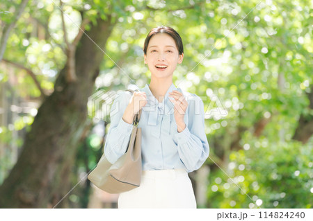 新緑の中で微笑むビジネスウーマン 新緑の中で微笑むビジネスウーマン 114824240