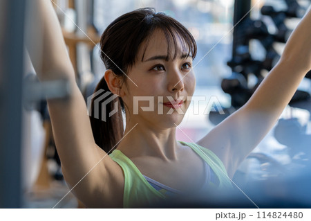 スポーツジムでトレーニングする若い女性 114824480