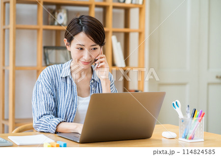 リビングでテレワークをするミドル女性。 リビングでテレワークをするミドル女性。 114824585
