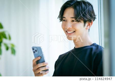 スマホを操作する若い男性 114824947