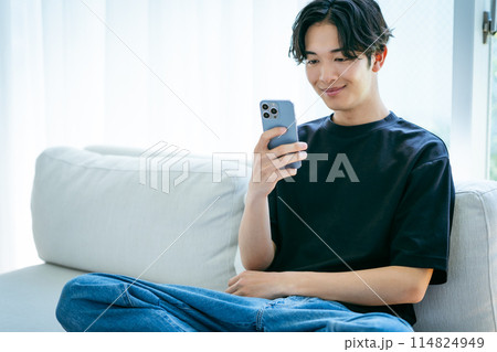 スマホを操作する若い男性 114824949